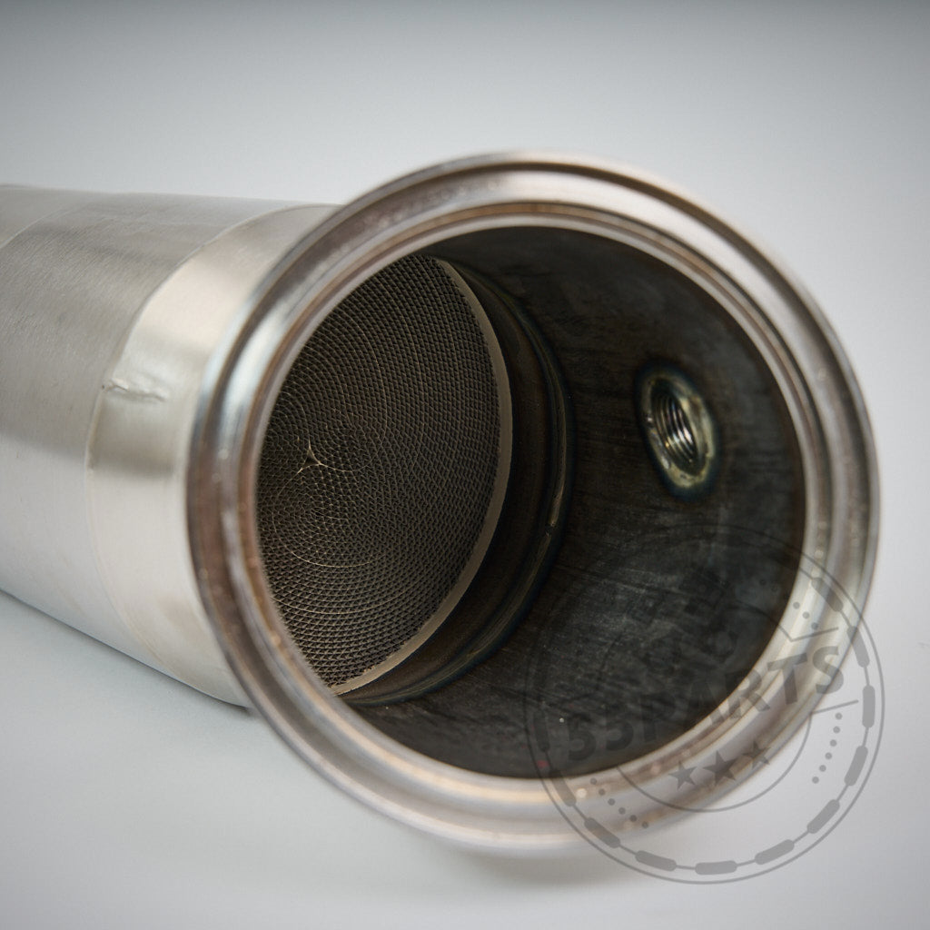 Nahaufnahme der 55Parts Eintragbare 300 Zeller Downpipe B58, ein zylindrisches Autoauspuffteil mit Netzfilter, kompatibel mit BMW M140i, M240i, 340i, 440i, 540i, 640i, und 740i F- & G-Serie OPF und NON OPF Modellen.