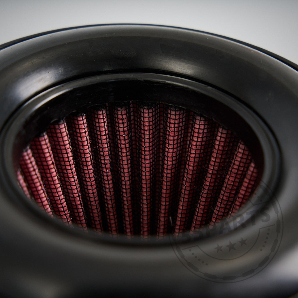 Nahaufnahme des 55Parts Austauschfilters für die B58/S58 und N55 offene Ansaugung, die die zylindrische Form, den schwarzen Gummirand und das rote Faltenfiltermaterial für den Einsatz im Automobil zeigt.
