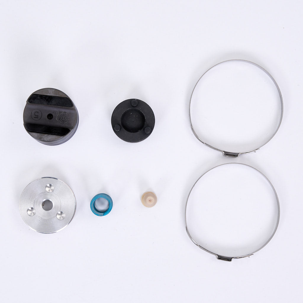 Sieben runde und zylindrische mechanische Teile, darunter das 55Parts Special EPS Druckstück Reparatursatz mit Spezialwerkzeug für BMW 1er, 2er, 3er und 4er F-Serien, übersichtlich angeordnet auf weißem Hintergrund.