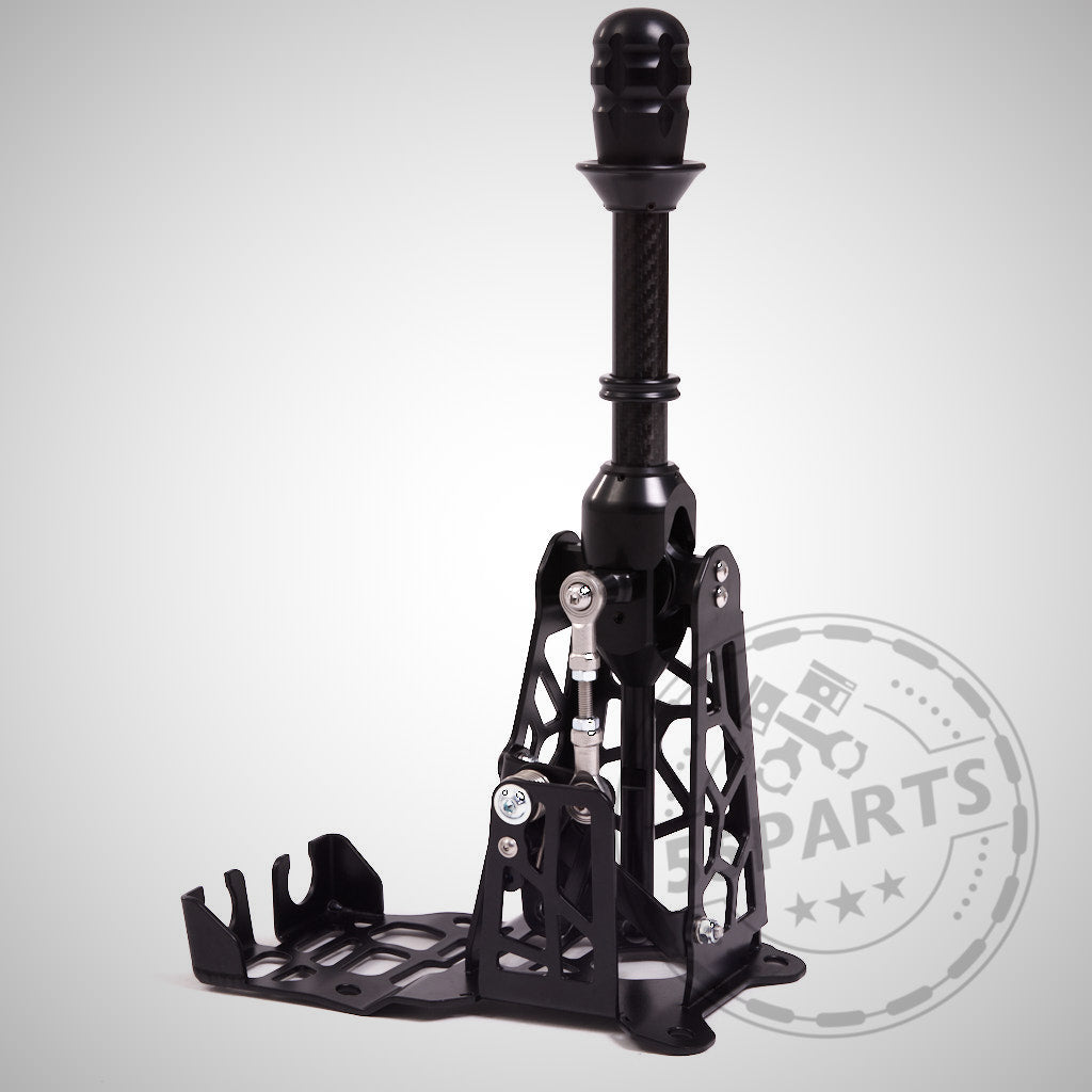 Der HRE Shortshifter passend für GR Yaris von HRE verfügt über einen stabilen Metallrahmen und eine offene Basis, die für hohe Leistung ausgelegt ist und auf einem schlichten Hintergrund dargestellt wird.