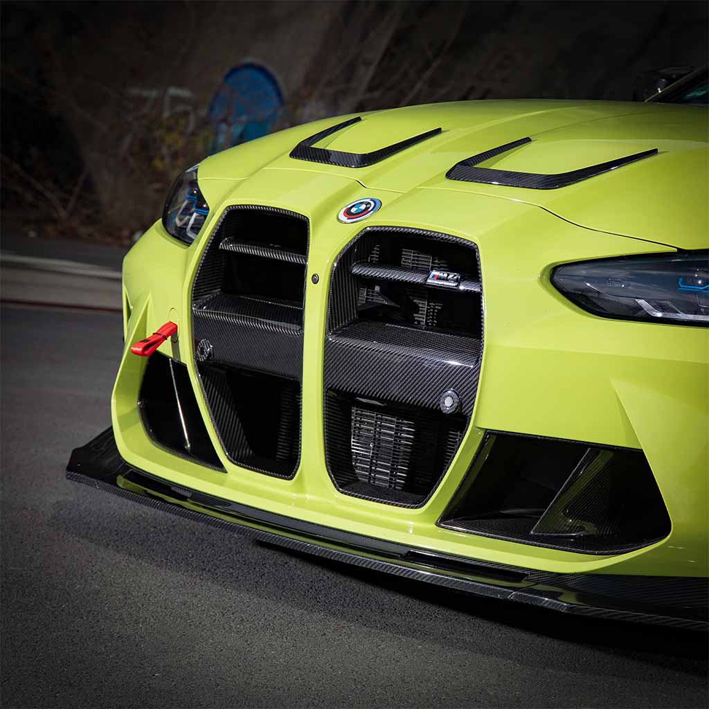 Nahaufnahme eines gelben BMW mit Twistnfix TNF+ V-Style Carbon Frontgrill, passend für BMW M3 (G80/G81) & M4 (G82/G83), inkl. Teilegutachten, mit Details aus Carbonfaser.