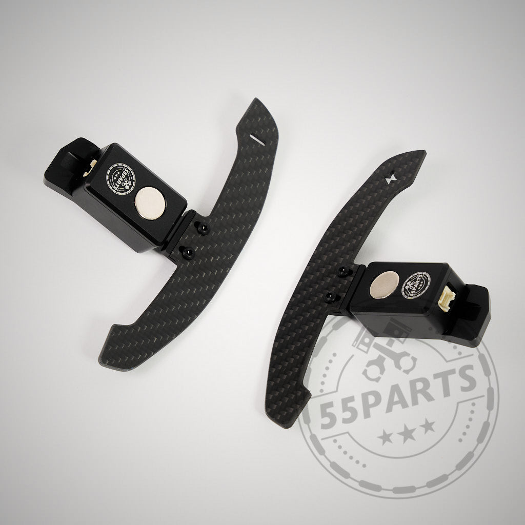 Die 55Parts Special magnetischen Schaltwippen (Rennsport) für den Toyota GR Yaris, hier mit schwarzem Sockel auf hellgrauem Hintergrund und 55Parts-Logo, sorgen für echtes Rennsport-Feeling.