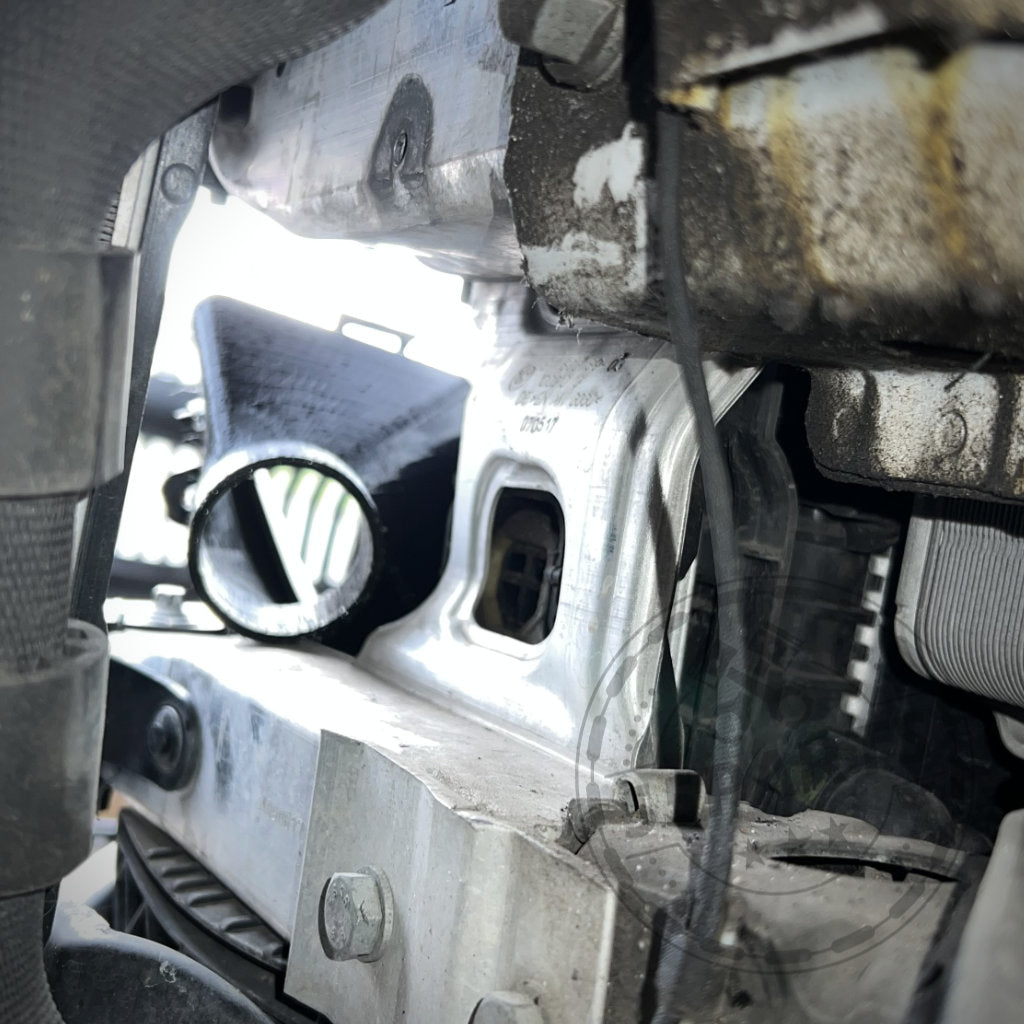 Nahaufnahme eines BMW 2er F22-Motors (M235i, M240i) mit einem abgelösten Schlauch und sichtbarem Schmutz – perfekt zum Tunen oder Einbauen des 55Parts Exclusive Bremsbelüftungssets vor Ihrem nächsten Rennen.