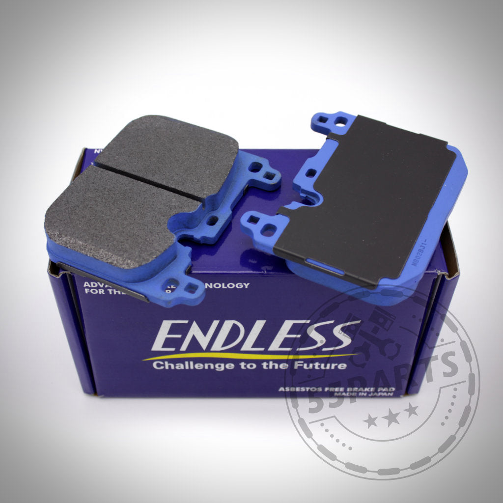 Zwei blau-schwarze Endless-Bremsbeläge befinden sich auf einer blauen Endless-Box mit weißem Text, entwickelt passend für BMW M135i/40i, M235i/40i, 335i/40i, 435i/40i, M2, M3 und M4 (F-Serie), ideal für den Einsatz auf der Rennstrecke.