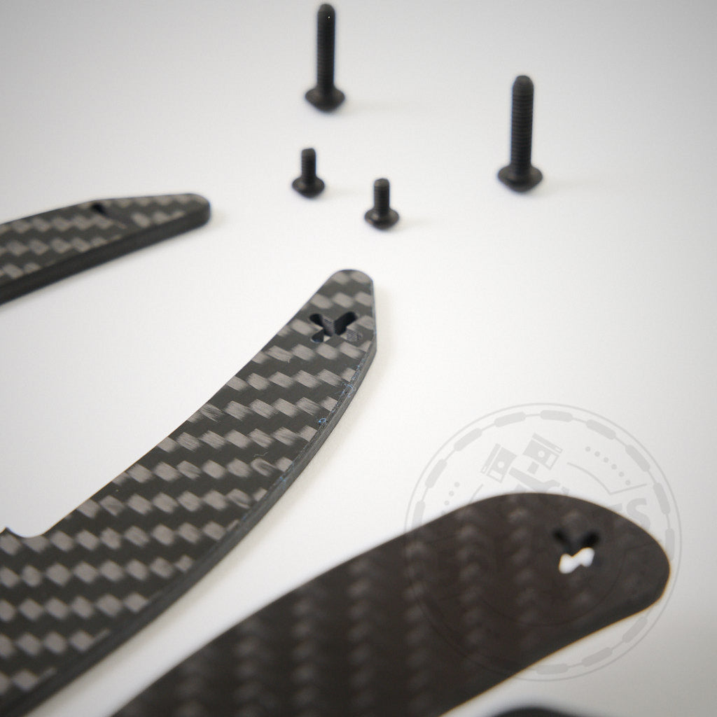 55Parts Spezial: Magnetisches Schaltwippen-Kit V2 (E9X M3) inklusive Carbonfaser-Wippen, Schrauben, Verkabelung und Inbusschlüssel. Rennsport-inspiriertes Design auf weißem Hintergrund.