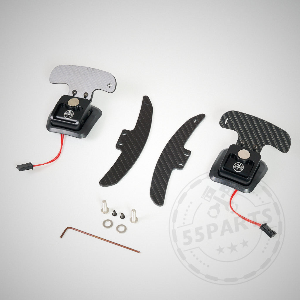 Das 55Parts-Special: Magnetische Schaltwippen V2 passend für BMW E9X M3, inklusive Kohlefaser-Schaltwippen, Verkabelung, zusätzlichen Schaltwippen, Schrauben, Inbusschlüssel und Kleinteilen, alles auf grauem Hintergrund dargestellt.