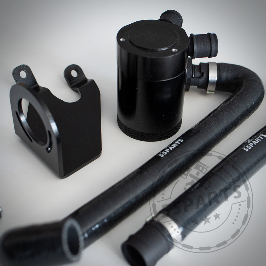 Schwarze Autokomponenten – einschließlich Schläuche und Kanister – aus dem exklusiven 55Parts Oil Catch Can System &amp; Bannik Engineering für Modelle der B58 F-Serie werden auf einer weißen Oberfläche angezeigt.