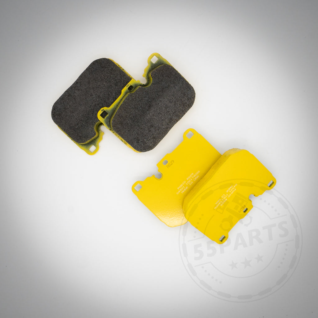 Zwei gelbe Pagid-Bremsbeläge für 6-Kolben-Bremssättel von BMW – einer zeigt die Reibfläche, der andere die Trägerplatte – passen für die Modelle F87 M2 Competition (Track Pack/CS), F80 M3, F82/F83 M4, F10 M5 und F13 M6.