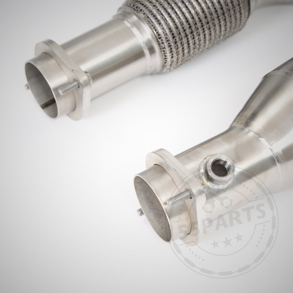 Nahaufnahme von zwei Edelstahl High Flow Downpipes (mit 200 Zeller Euro 6 Katalysatoren), passend für BMW G87 M2, G80 M3, G82 M4 S58 von 55Parts &amp; MH Pipes mit Flanschen und Schweißnähten auf weißem Hintergrund.