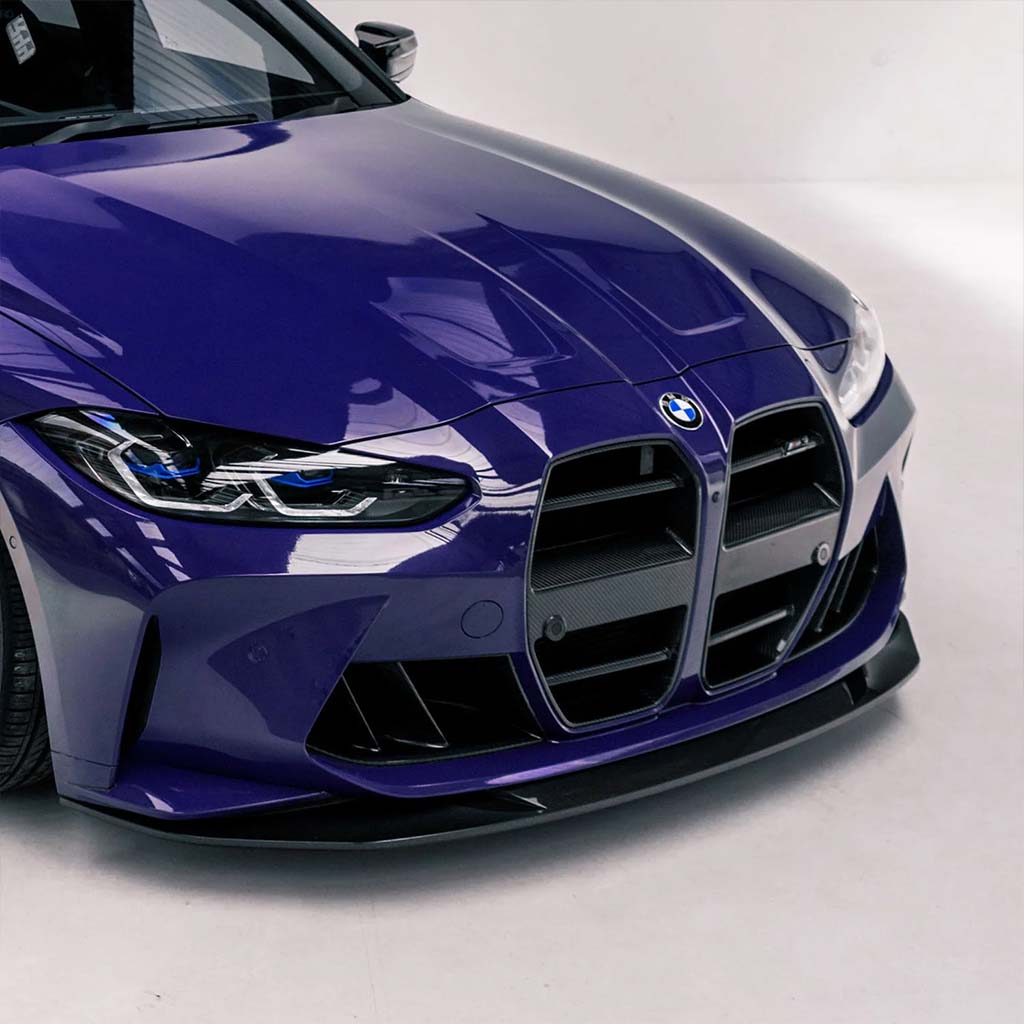 Nahaufnahme der Frontpartie mit Twistnfix MHC TNF+ Lufteinlässe Double-Ducts in Carbon, passend für BMW M3 (G80/G81) &amp; M4 (G82/G83), mit Hervorhebung des markanten Kühlergrills, der Scheinwerfer und des leistungssteigernden Designs.