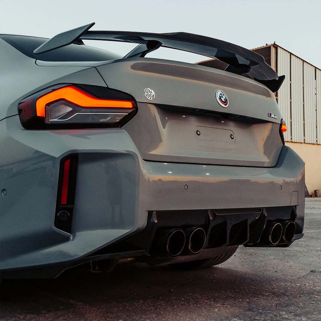 Drei Twistnfix MHC TNF+ Edition 1 Heckdiffusor Carbon Teile für BMW M2 (G87) inkl. Teilegutachten im OEM-Style mit roten Akzenten werden auf weißem Hintergrund dargestellt.