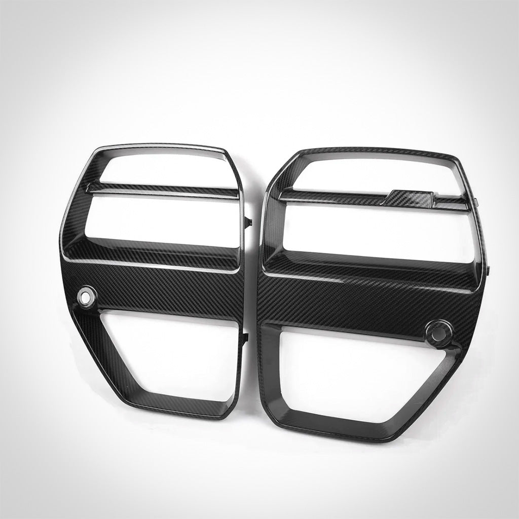 Zwei schwarze TNF+ V-Style Carbon Frontgrill Zierleisten von Twistnfix für BMW M3 (G80/G81) und M4 (G82/G83), inkl. Teilegutachten, mit offenen Schlitzen, dargestellt auf weißem Hintergrund.