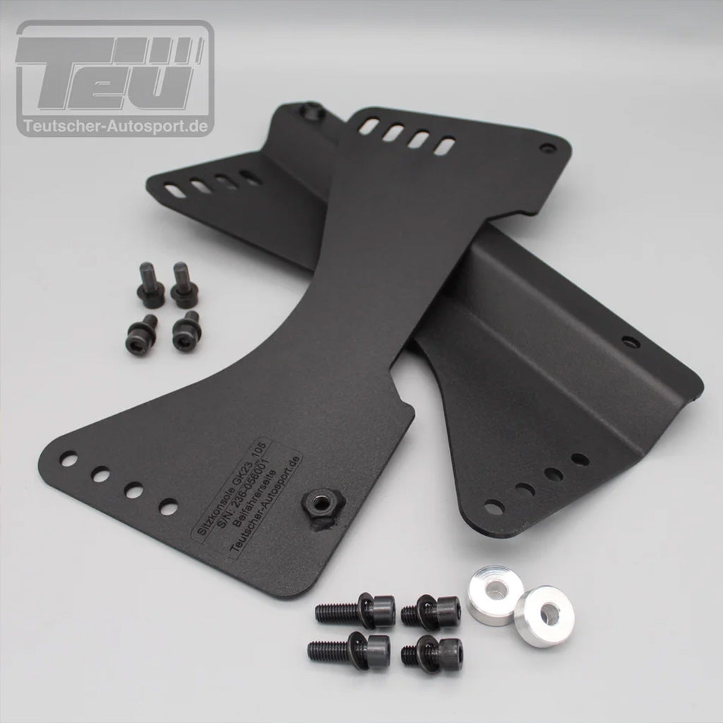 Zwei schwarze Metallhalterungen mit Schrauben und Unterlegscheiben auf grauer Oberfläche - perfekt als Teutscher Recaro Pole Position Sitzkonsolen für Mini F5x inkl. Materialnachweis.
