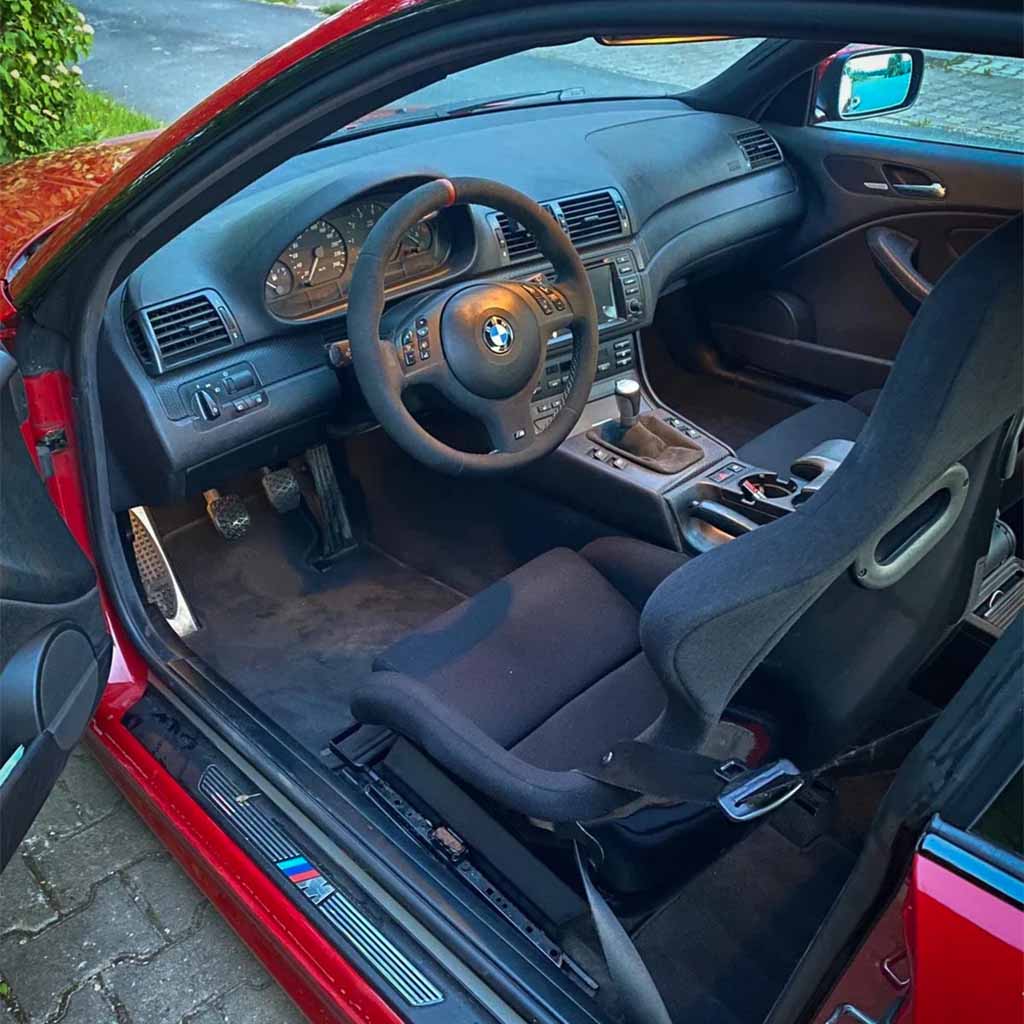 Roter BMW Innenraum mit Teutscher Recaro, Sparco, OMP Sitzkonsolen für BMW E46/E85/E86 Z4 (mit Materialzertifikat), Schaltgetriebe und Sportlenkrad, von der Fahrerseite aus gesehen.