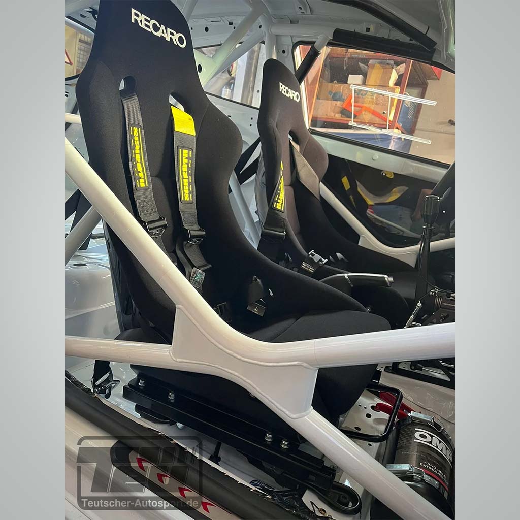 Zwei schwarze Recaro Rennsitze mit Gurten werden mit Teutscher Recaro, Sparco, OMP Sitzkonsolen passend für Ford Fiesta MK.7 inkl. Materialnachweis montiert. Materialnachweis in einem Auto mit weißem Überrollkäfig und Motorsport-Interieur.
