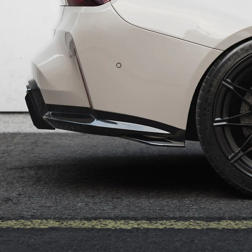 Nahaufnahme eines BMW M3 mit einem ZAERO Design EVO-S Diffusor Erweiterung installiert, schwarzes Rad, geparkt an einer weißen Wand auf der Straße.