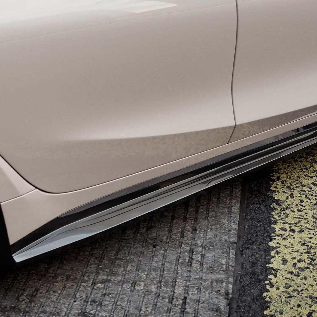 Nahaufnahme eines weißen BMW M3 G80 mit ZAERO Design EVO-S Seitenschweller und schwarzem OEM+ Design Leichtmetallrad, geparkt auf Asphalt.