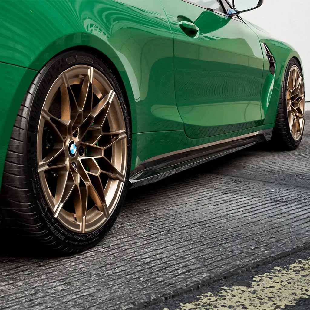 Grüner BMW M4 G82 mit ZAERO Design EVO-S Seitenschweller von ZAERO, geparkt auf einer strukturierten Betonfläche.