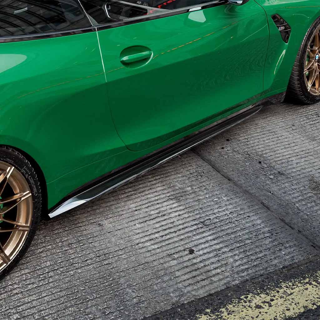 Grüner BMW M4 G82 mit ZAERO Design EVO-S Seitenschweller von ZAERO, geparkt auf einer strukturierten Betonfläche.