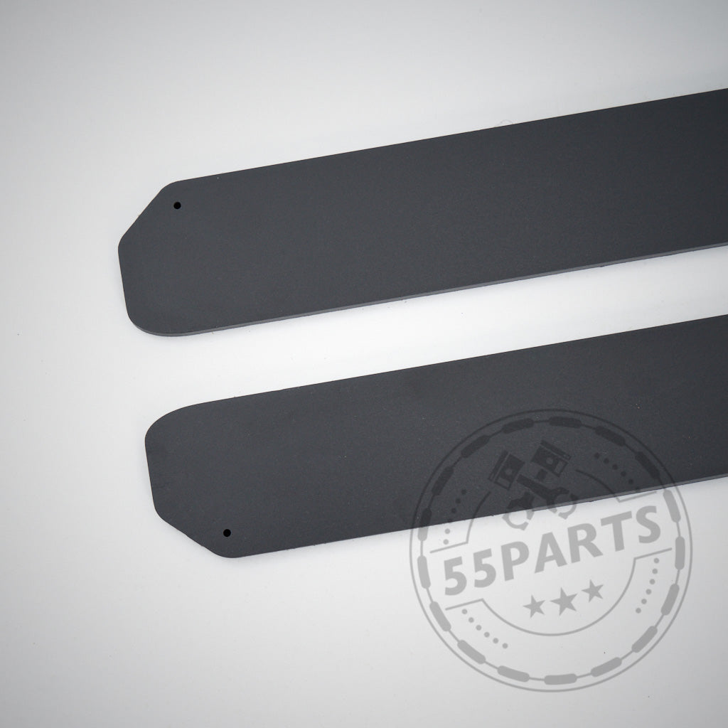 Zwei mattschwarze Seitenschweller aus Kunststoff PE, entworfen passend für BMW F87 M2, M2 Competition und M2 CS, liegen parallel auf einer hellen Oberfläche – ideal, um den Stil Ihres Autos aufzuwerten.
