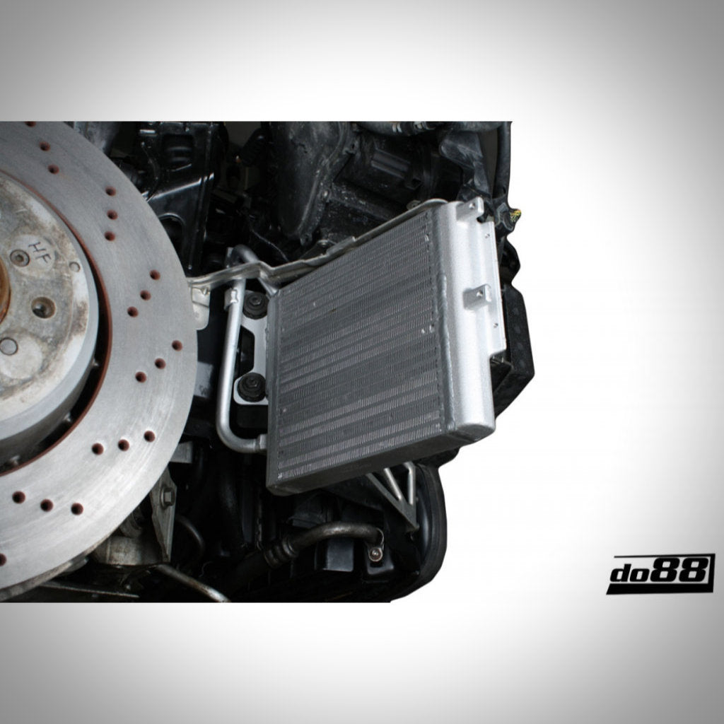 Nahaufnahme eines do88 DKG und Schaltgetriebe-Ölkühlers Rennsport passend für BMW E9x M3 S65, mit Ladeluftkühler und Scheibenbremse im Motorraum sichtbar. do88-Branding abgebildet – ideales Setup für effiziente Streckenkühlung.