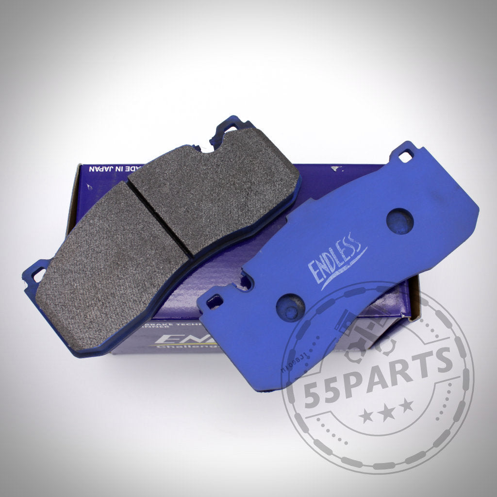 Zwei blaue Endless-Bremsbeläge passend für Toyota Yaris GR liegen auf einer violetten Schachtel, mit einem Yaris GR und einem 55Parts-Logo-Wasserzeichen im Toyota-Stil in der Ecke.