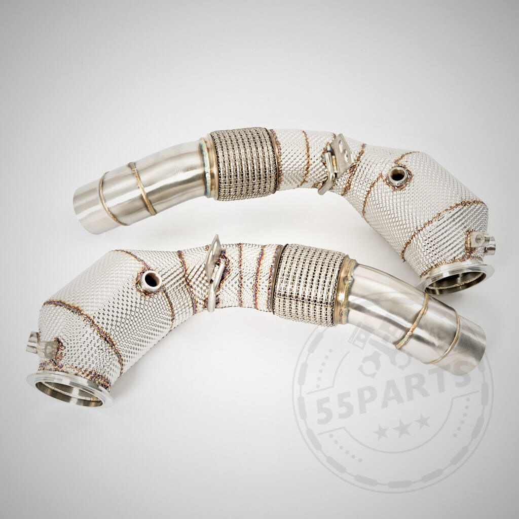 Auf hellem Hintergrund sind zwei metallische 55Parts High Flow Downpipes thermoisoliert mit 200 Zeller Katalysatoren, passend für BMW M5, M6 F10, F11, F12, F13 S63, mit Hitzeschild und Netzabdeckung abgebildet.