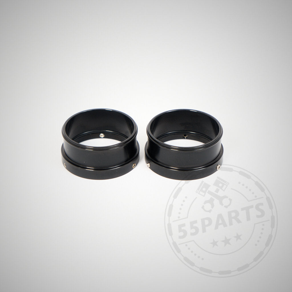 Zwei schwarze zylindrische Metallringe – 55Parts Adapter für Montage von 2" Silikon Inlets auf 1,75" Turbos, passend für BMW 135i, 1er M Coupe, 335i(x) N54 – liegen nebeneinander auf hellgrauem Hintergrund.