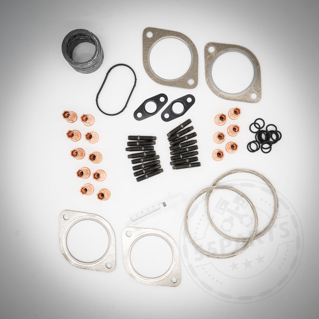 55Partss Turbolader-Einbauset passend für BMW 135i, 1er M Coupe, 335i(x) N54 mit sortierten Dichtungen, Schrauben, Ringen und Dichtungen (Anbauteile), angeordnet auf einer weißen Fläche.