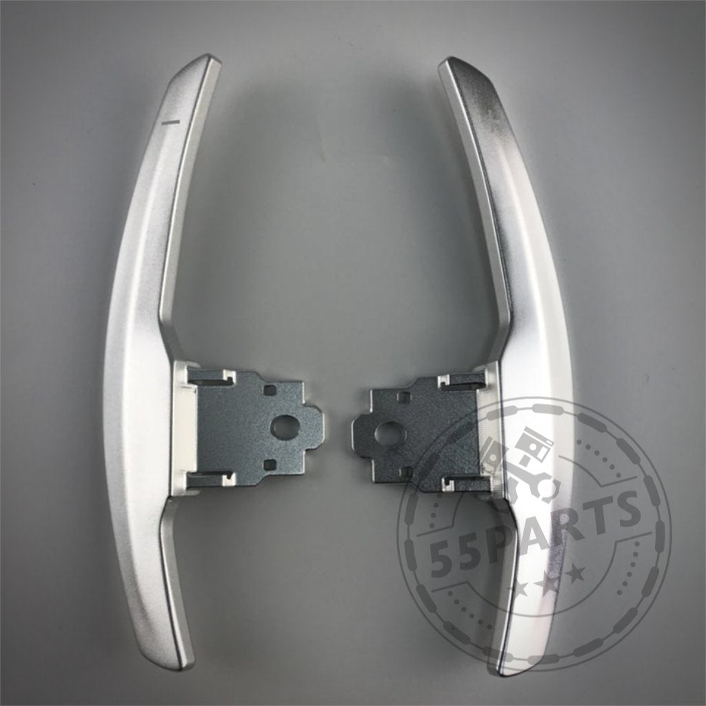 Zwei Aluminium/Carbon Schaltwippen von 55Parts für BMW 1/235 & 40i, 3/435 & 40i, M2, M3 & M4 F-Serie sind nebeneinander auf grauem Hintergrund abgebildet.